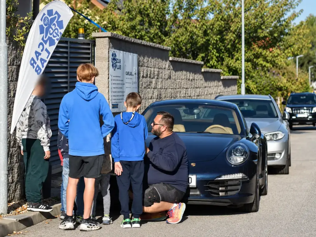Děti z kroužku Junior Technik u vozu Porsche 911 před servisem CarLab
